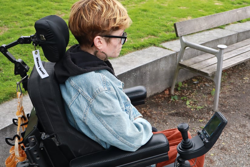 Bild på assistansberättigad som sitter ensam i en park Fotograf Elin Hörnfeldt