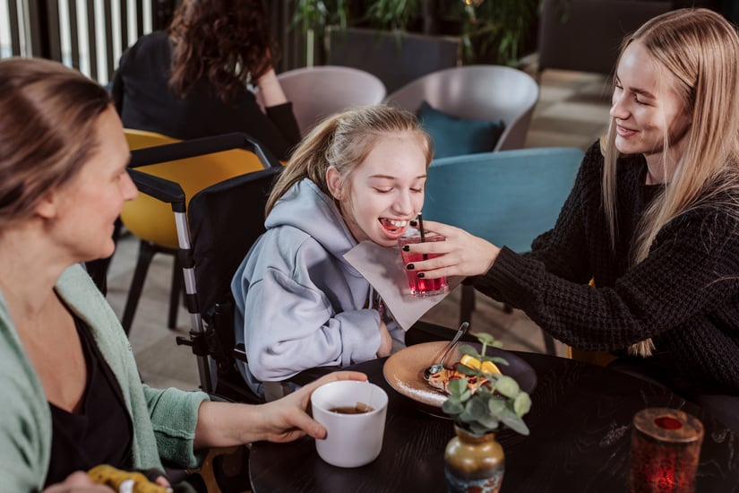 Flicka som får assistans med sin måltid