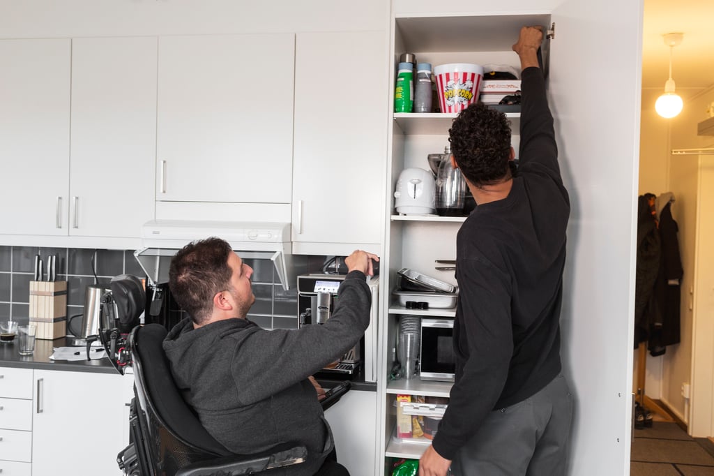 Personlig assistent assisterar assistansanvändaren med att ta fram från skafferiet