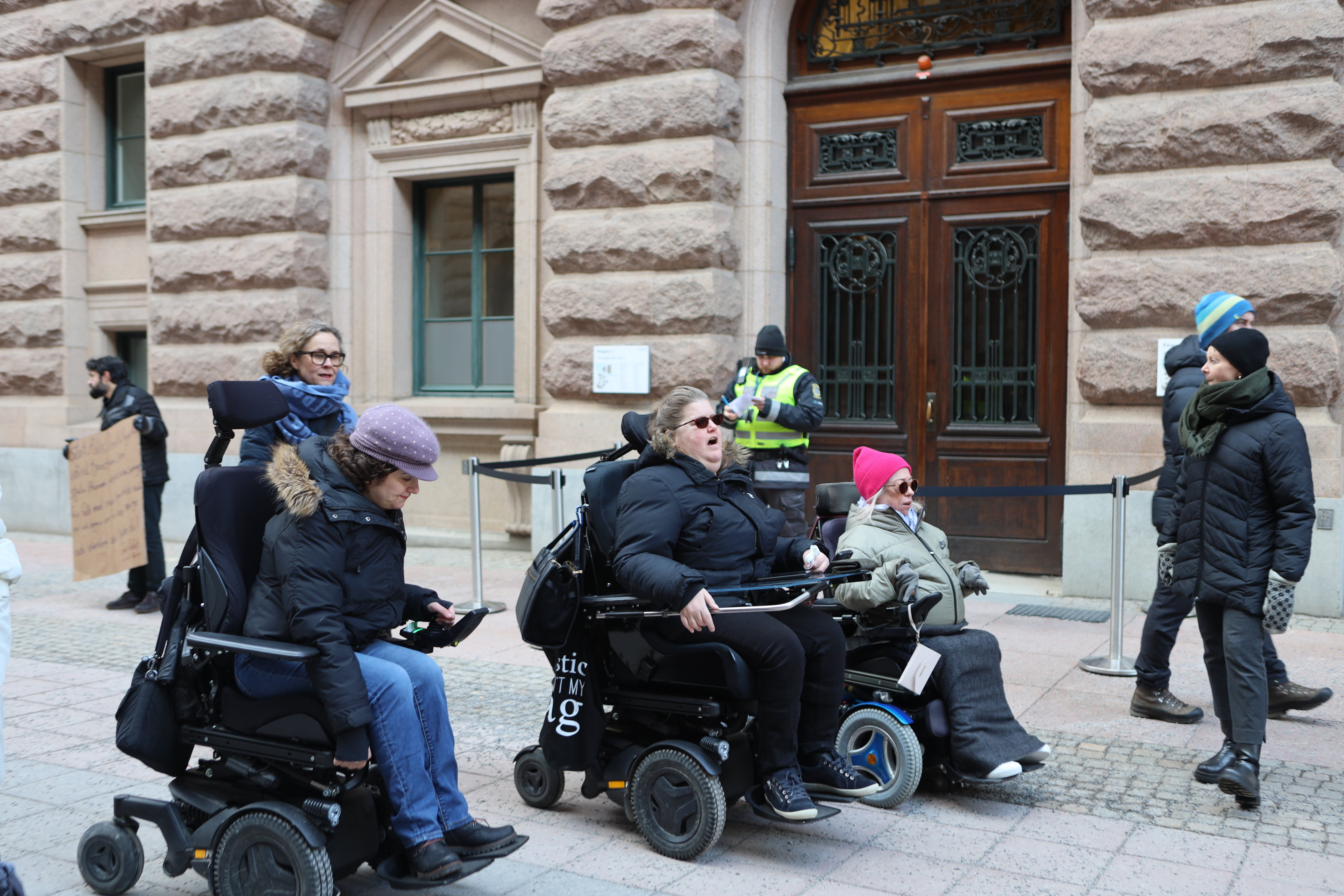 bild på medlemmar utanför riksdagen, blickarna framåt