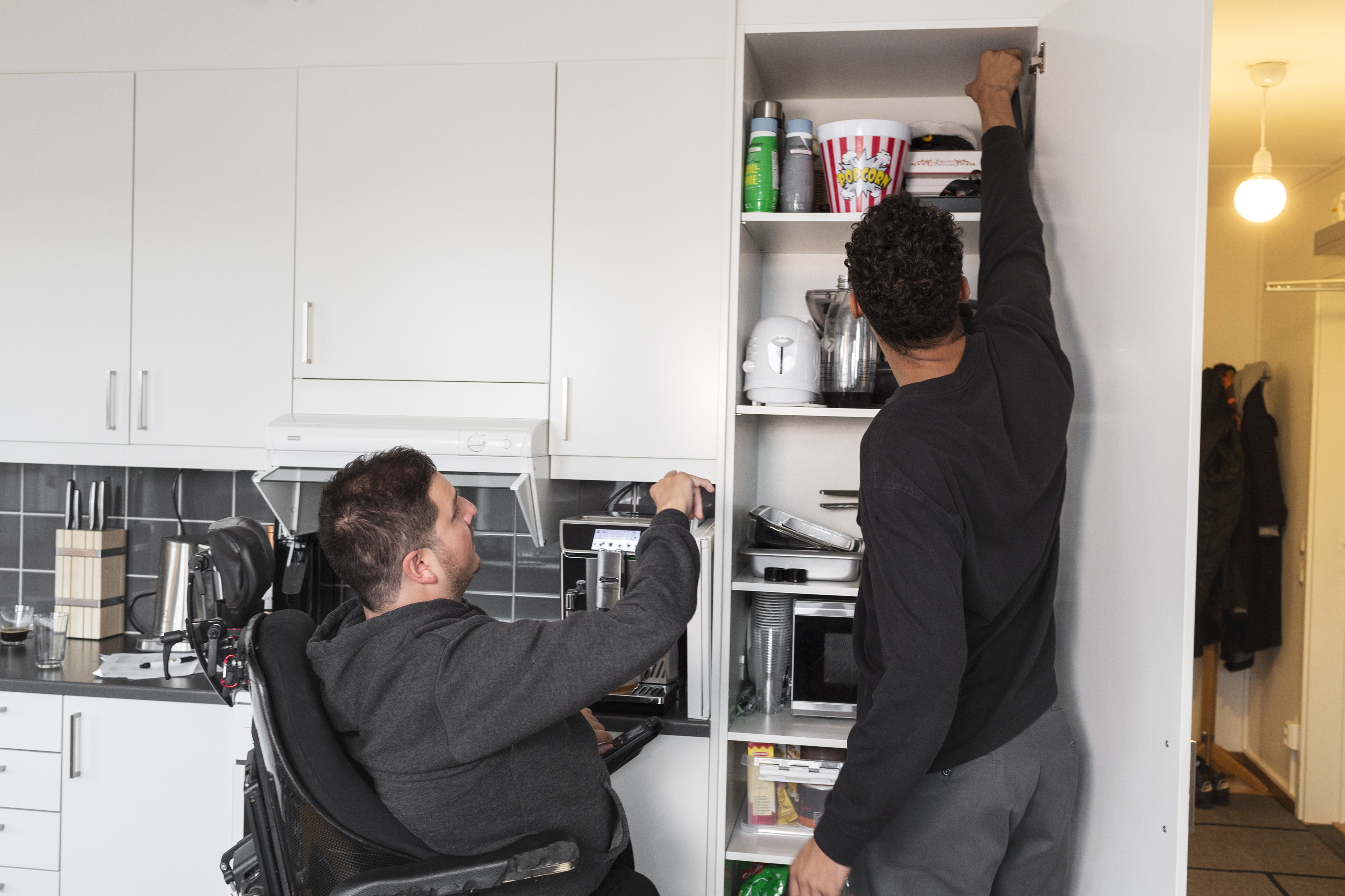 Personlig assistent assisterar assistansanvändaren med att ta fram från skafferiet