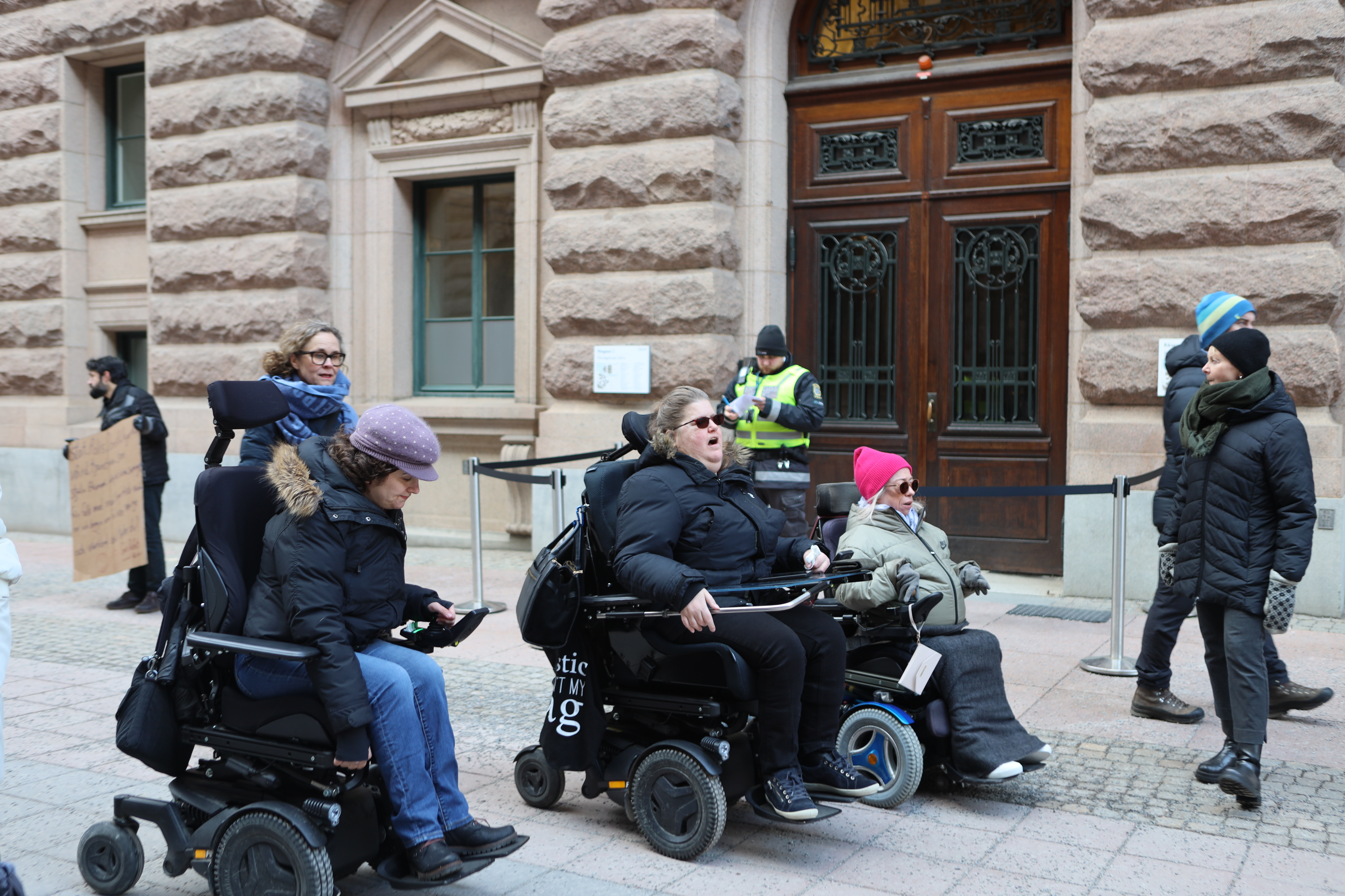 bild på medlemmar utanför riksdagen, blickarna framåt